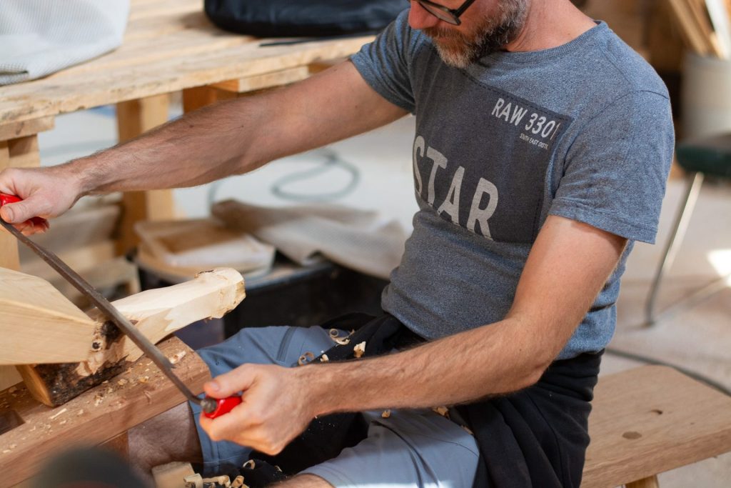 Homme sciant bois dans atelier de menuiserie
